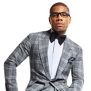 A man wearing a grey plaid suit, white shirt, and black bow tie with black-rimmed glasses.